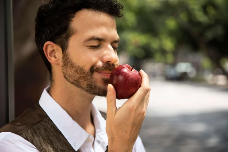 Hombre comiendo manzana para cuidar sus dientes